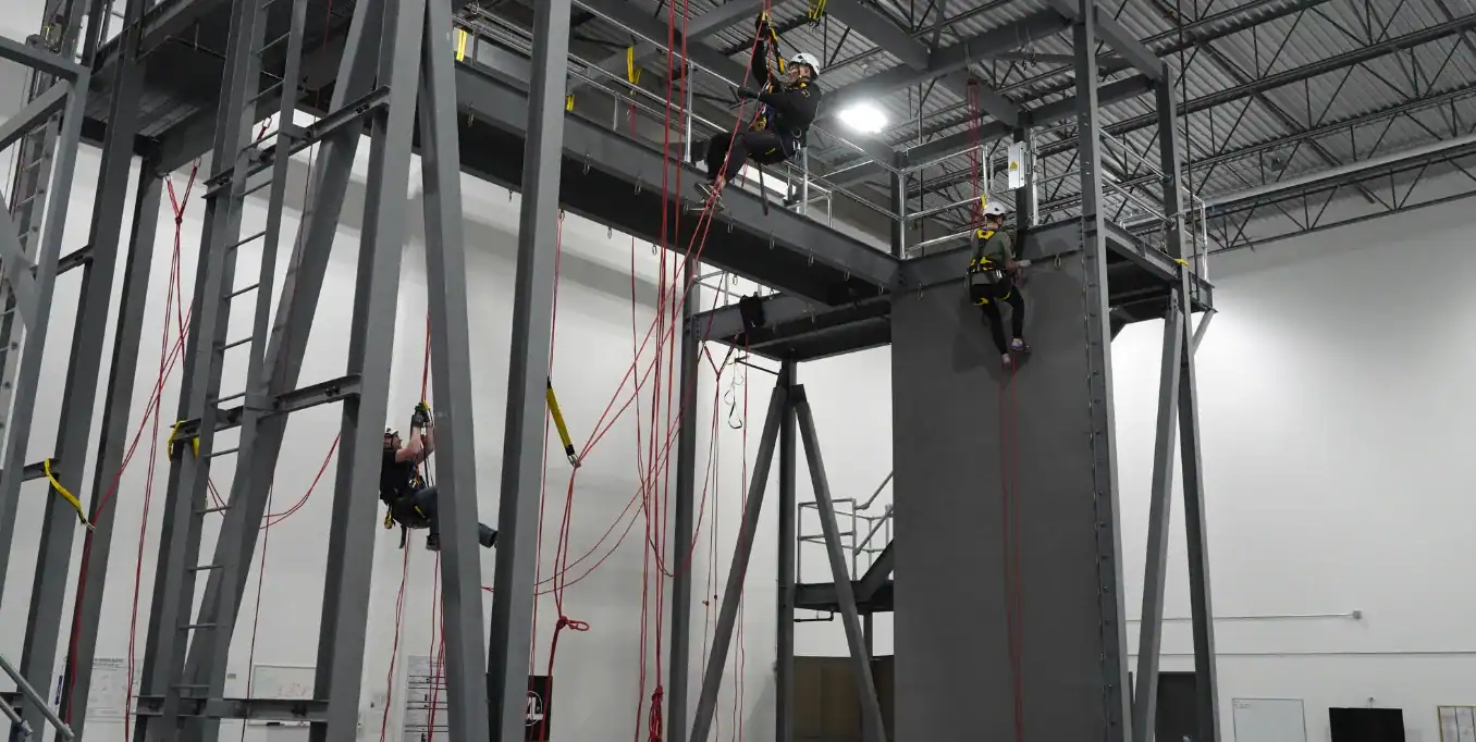 Workers receiving accredited fall protection training with harnesses, anchors, and safety systems in Calgary, Canada.